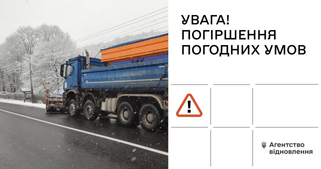 Велика синя вантажівка їде по дорозі під час снігопаду, попередженийя про погіршення погодних умов.
