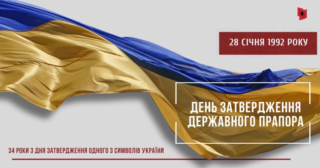 Прапор України із синьою та жовтою смугами хвилеподібно майорить на тлі напису про день затвердження державного прапора 28 січня 1992 року.