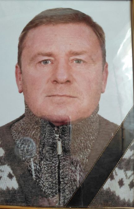 Чоловік з коротким світлим волоссям у светри з високим коміром і візерунком дивиться прямо в камеру.