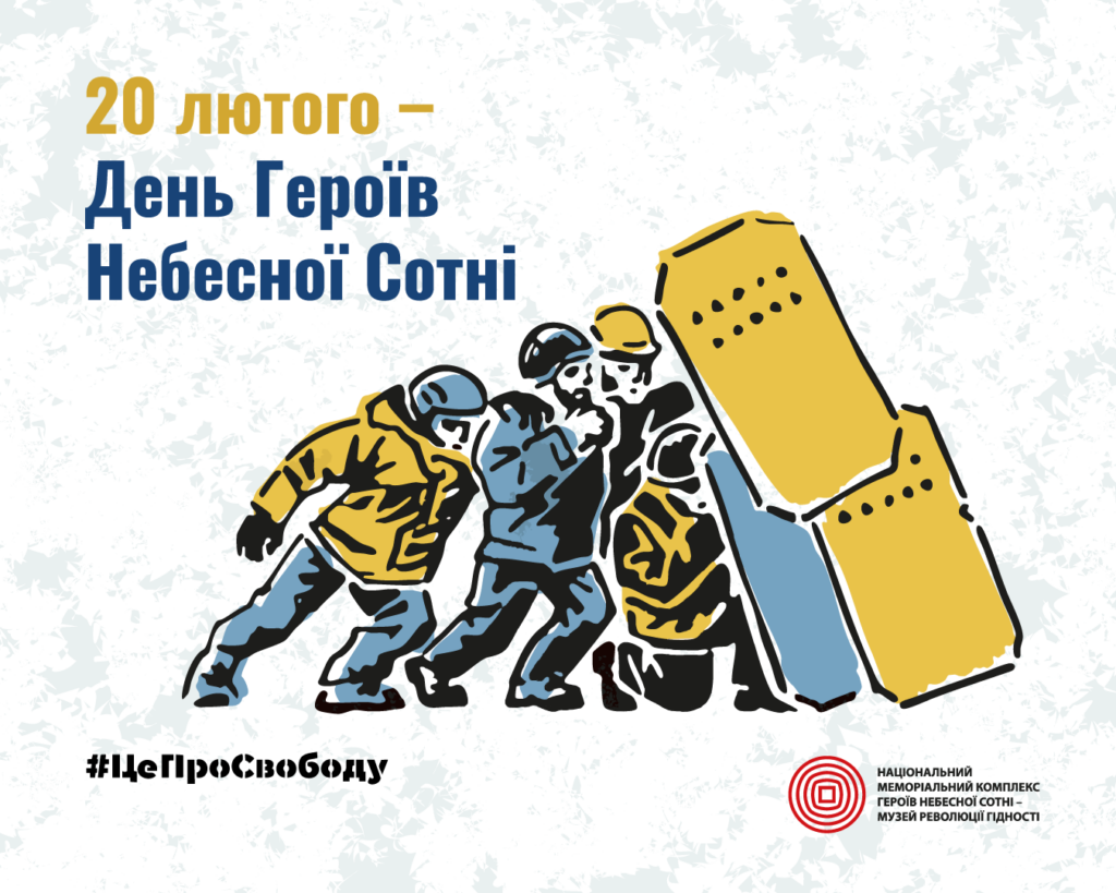 Троє людей у спецодягу піднімають велику жовто-блакитну баррикаду.