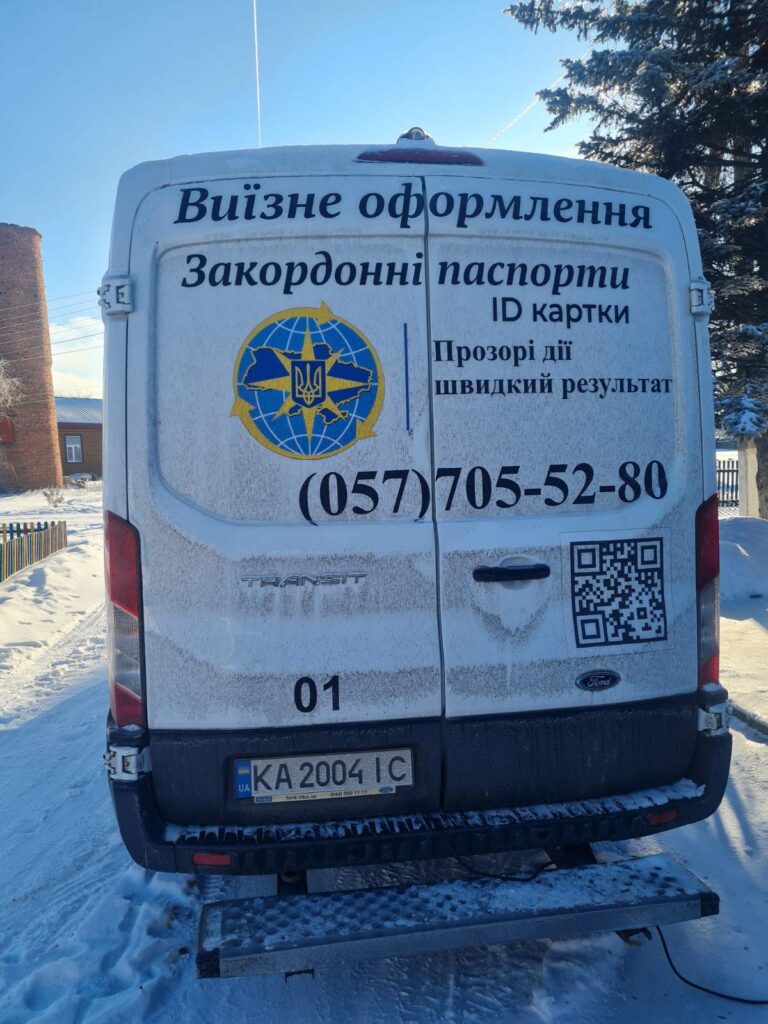 Біла вантажопасажирська машина з інформацією про виїздне оформлення закордонних паспортів та ID-карток.
