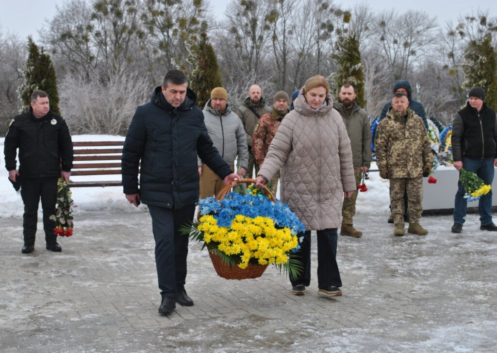 Чоловік та жінка несуть кошик із квітами жовто-блакитного кольору.