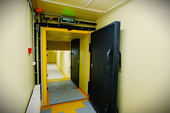 Відкриті чорні двері ведуть до жовтого коридору з підсвіткою, а над ними розміщений напис 