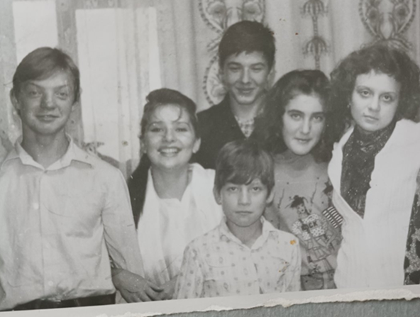 Чорно-біле сімейне фото, на якому шестеро людей різних вікових груп, переважно у світлому одязі, посміхаються перед камерою.