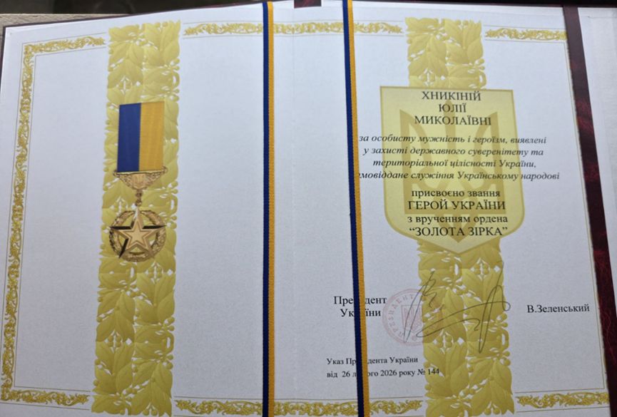 Бланк нагородного документа із золотою орнаментальною рамкою та зображенням ордену із стрічкою українських національних кольорів, підпис Президента України із печаттю.