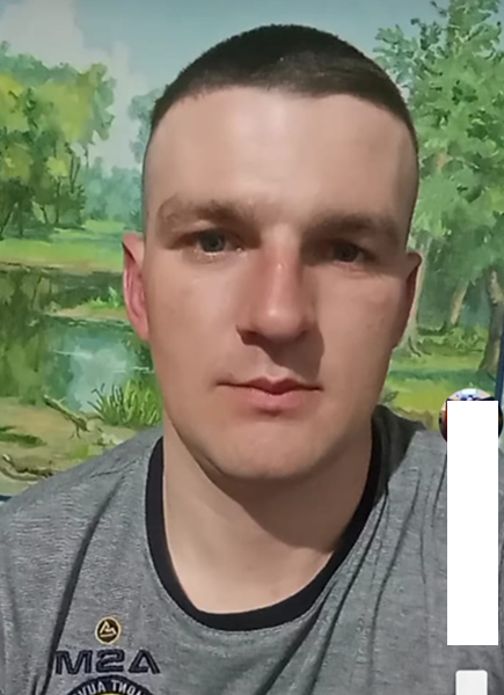 Молодий чоловік із короткою стрижкою дивиться прямо в камеру, на ньому сіра футболка з логотипом M2A.