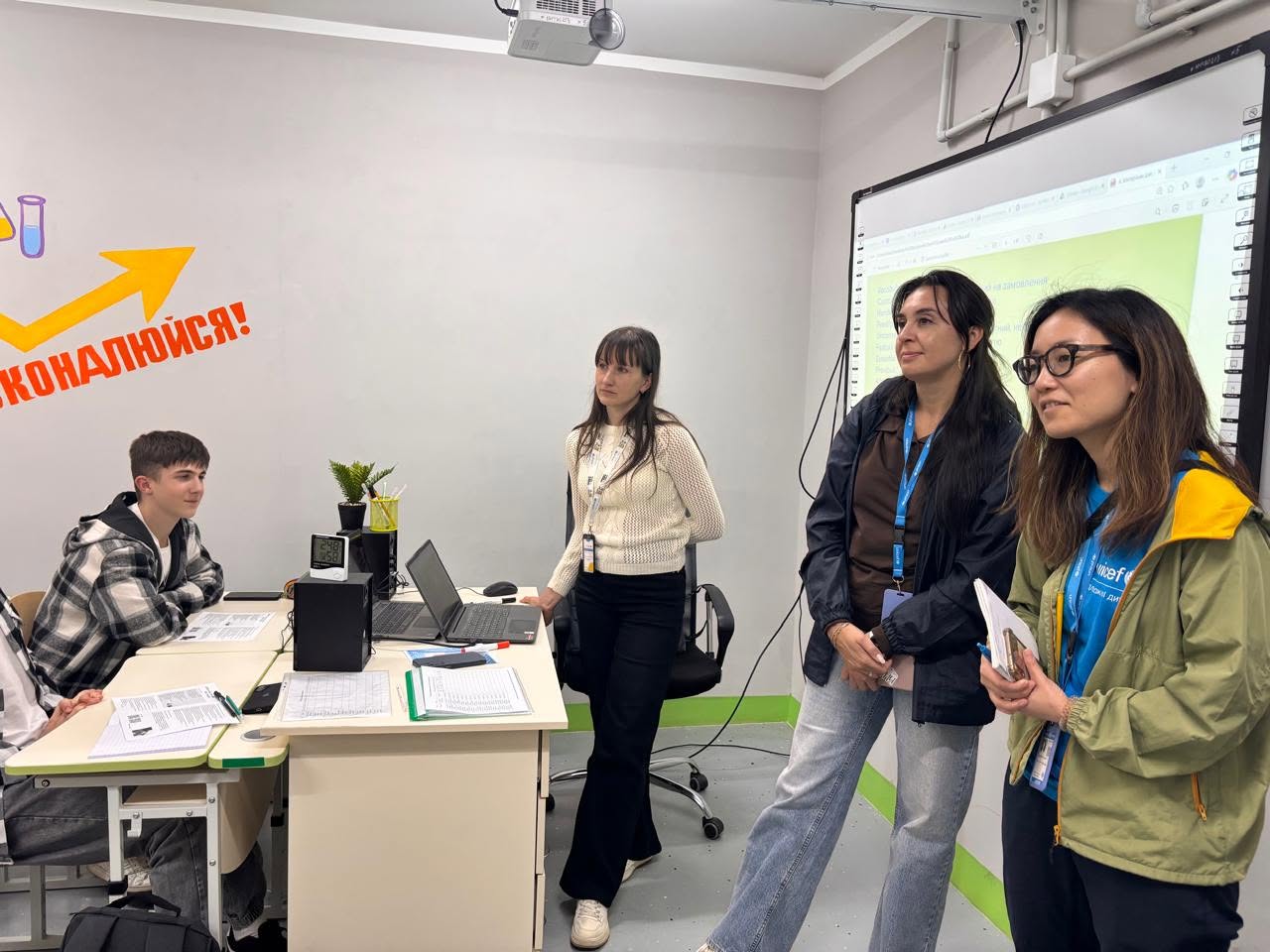 Учасники освітнього заходу в аудиторії з проєктором та написом «УСПІХ ПОЧАЛИСЬ!» на стіні.
