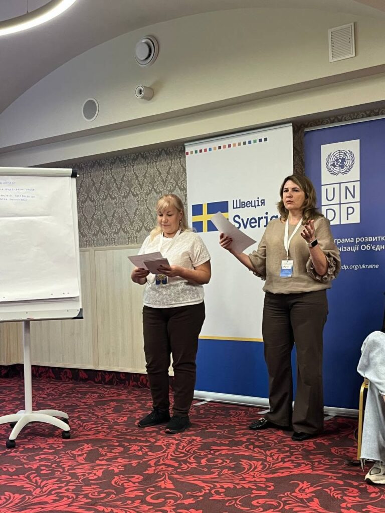 Дві жінки читають вголос документи на заході ООН у Швейцарії.