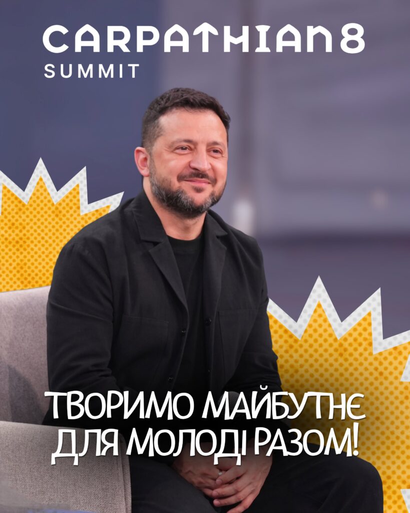 Чоловік у чорному костюмі сидить на дивані на тлі банера з написами 