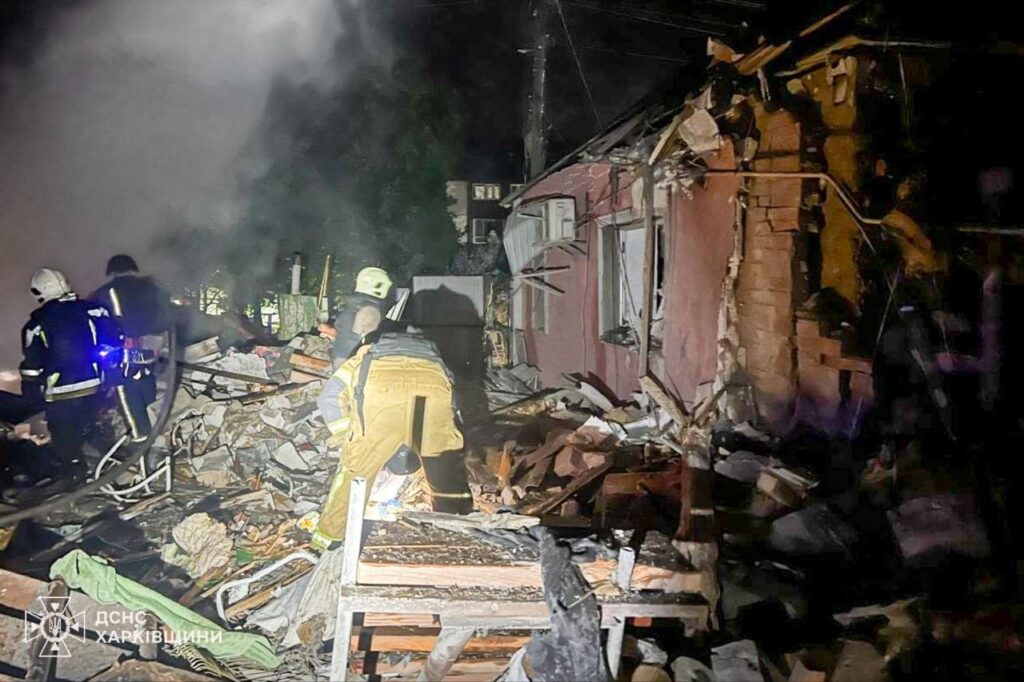 Рятувальники ДСНС Харківщини працюють серед уламків зруйнованої будівлі вночі.